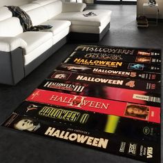 a living room area with a white couch and halloween themed rugs on the floor