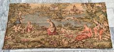 an old tapestry with people and animals on it in the middle of a tile floor