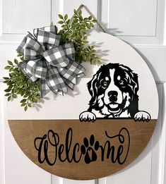 a welcome sign with a dog on it and a bow hanging from the front door