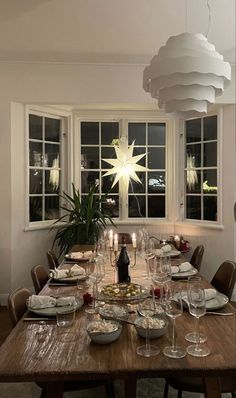 a dining room table is set with wine glasses and plates