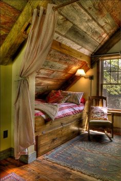 an attic bedroom with wood floors and exposed ceilings, has a bed made out of wooden planks