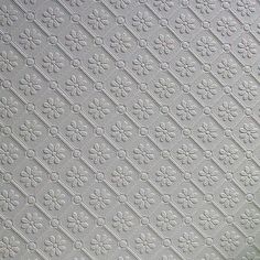 a close up view of the ceiling in a room with white tiles and flowers on it