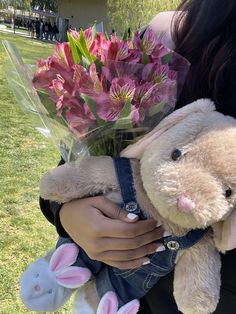 a person holding a stuffed animal and flowers