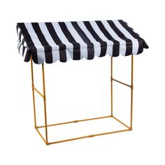 a black and white striped awning on a gold frame stand with an open top