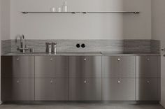 a kitchen with stainless steel cabinets and counter tops in the center, along with two sinks on each side