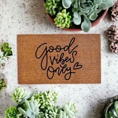 a door mat with the words good vibes only on it next to succulents