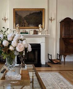 a living room filled with furniture and flowers in a vase on top of a coffee table