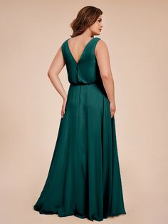 a woman in a long green dress with her back to the camera, looking over her shoulder