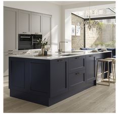 a large kitchen with an island and bar stools