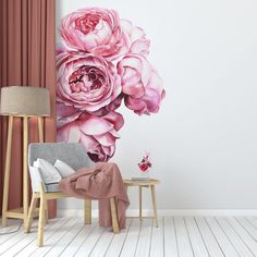 a living room with pink flowers on the wall and a chair in front of it