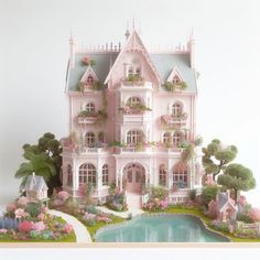 a pink doll house with lots of windows and flowers on the roof, next to a pond