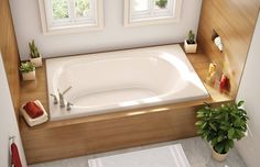 a bathroom with a bathtub, toilet and plants on the counter top in front of two windows