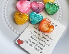 there are many heart shaped candies on the plate next to a card that says you are enough