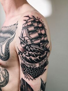 a man's half sleeve with an old ship and fish tattoo on his left shoulder