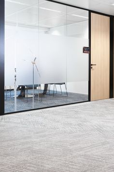 an empty room with glass walls and chairs