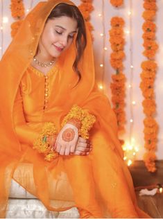 a woman in an orange outfit sitting down