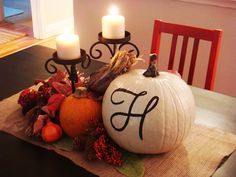 two pumpkins sitting on top of a table next to candles