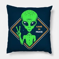 a pillow with an alien holding up the peace sign and saying, came in peace