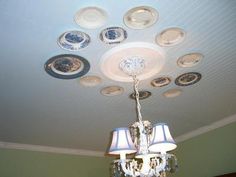 a chandelier hanging from the ceiling in a room with many plates on it