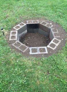 an outdoor fire pit in the middle of some grass