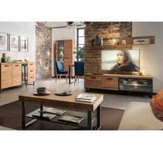 a living room filled with furniture and a flat screen tv on top of a wooden table