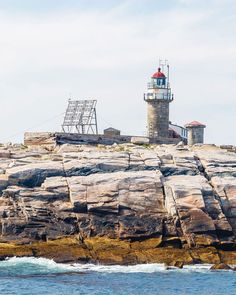 a light house sitting on top of a rocky cliff next to the ocean