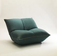 a green pillow sitting on top of a white floor