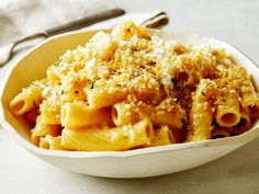 a white bowl filled with pasta covered in parmesan cheese