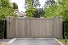 a wooden gate in the middle of a driveway