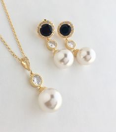 Simple and classic!! I've created these elegant cubic zirconia and Swarovski pearl bridal earrings in gold plated brass setting. Earrings feature large 12mm Swarovski pearls that dangle from brilliant cut black cubic zirconia with halo setting ear stud. Halo setting gives a brilliantly beautiful effect. Total length of the earrings is 3.8 cms. For matching necklace click: https://www.etsy.com/listing/763705554/gold-large-pearl-bridal-necklace-gold?ref=shop_home_active_1 For a set click: To brows Bridal Jewelry Pearl Sets, Black Pearl Earrings, Bridal Halo, Black Bridesmaid, Gold Bridal Necklace, Bridal Pearl Necklace, Black Gold Jewelry, Pearl Bridal Jewelry, Black Bridal