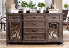 an old dresser with flowers and pictures on it's top shelf in front of a mirror