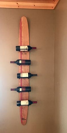 a surfboard mounted to the wall with wine bottles on it