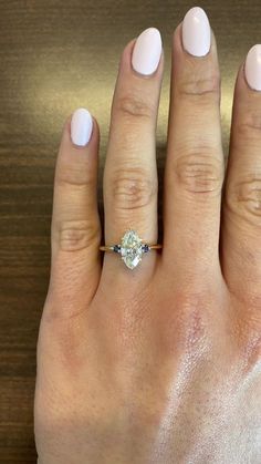 a woman's hand with a ring on it and a diamond in the middle