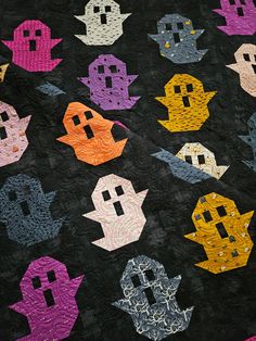 a quilt made to look like pacman's faces on a black background with different colors