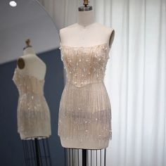 In stock and ready to ship in 2-3 business days! This transparent rhinestone and fringe tassel mini dress is perfect for any occasion! In addition to the faux pearl and rhinestone embellished bodice, this dress features cascading layers of sparkling crystals tassels along the bottom, providing eye-catching sparkle.There is a bra cup built into the dress. If you want coverage in those special areas, a bra, underwear, slip or whatever you choose can be worn underneath! Material: polyester, tulle C Elegant Mini Dress With Rhinestone Fringe For Prom, Elegant Beaded Fringe Mini Dress For Party Season, Elegant Beaded Fringe Mini Dress For Cocktail, Elegant Cocktail Mini Dress With Beaded Fringe, Elegant Mini Dress With Tassels For Evening, Pearl Dresses, Cascading Layers, Bra Cup, Pearl Dress