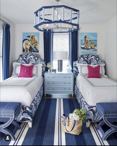 two beds in a room with blue and white decor on the walls, along with a striped rug