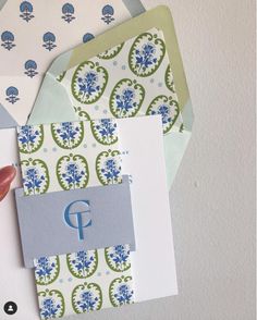 someone is holding up some cards with the letter f on them, and another card has a monogram in it