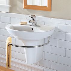 a white sink sitting under a bathroom mirror next to a wooden shelf with a towel on it