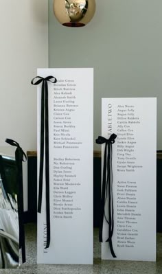 two black and white menus tied to each other in front of a large mirror