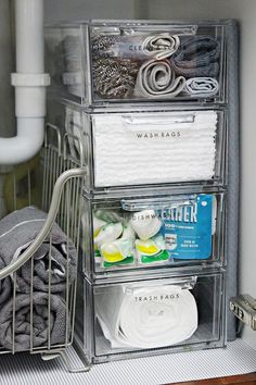 three clear drawers with towels and other bathroom items in the bins next to each other