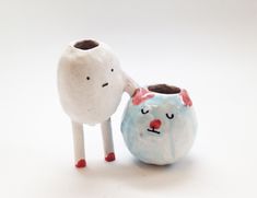 two small ceramic animals standing next to each other