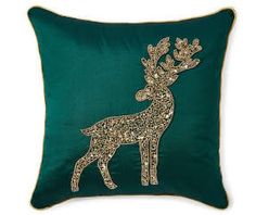 a green pillow with gold glitter deer on it