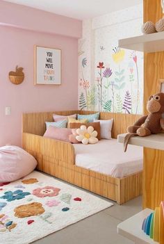 a child's bedroom with pink walls and floral wallpaper on the walls, including a wooden daybed