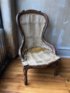 an old chair sitting on top of a hard wood floor