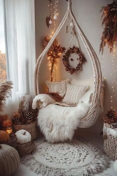 a white hammock hanging from the ceiling in front of a window filled with christmas decorations