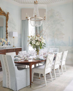 the dining room table is set with white chairs