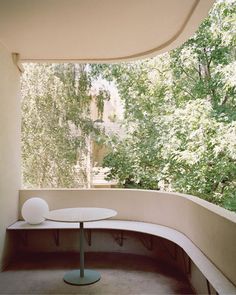 a white table sitting on top of a balcony next to trees