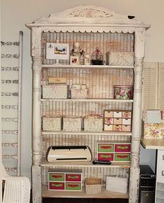 an old white bookcase with lots of boxes on it