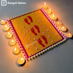 a decorated mat with lit candles and footprints on it for diwaling the festival