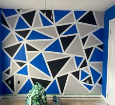 a room with blue and white wallpaper that has triangles painted on the walls in it